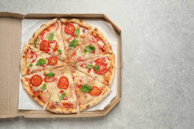 Margherita pizzası açık gri masada kutuda, üst tarafta. Metin için boşluk