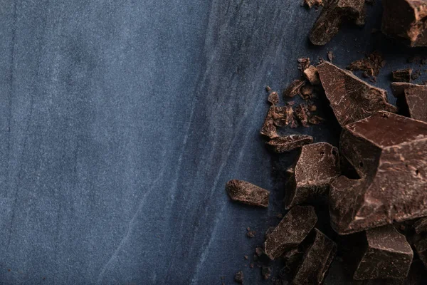 Pezzi Cioccolato Fondente Sul Tavolo Marmo Blu Posa Piatta Spazio — Foto Stock