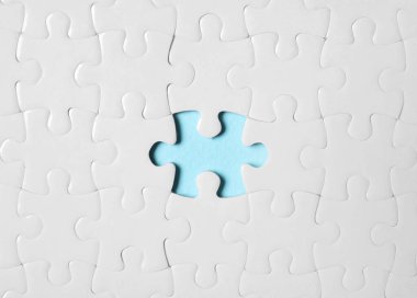 Açık mavi arkaplanda eksik parçalı boş beyaz bulmaca, üst görünüm