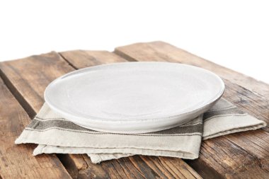 Boş tabak ve peçete beyaz arka plana karşı ahşap masaya.