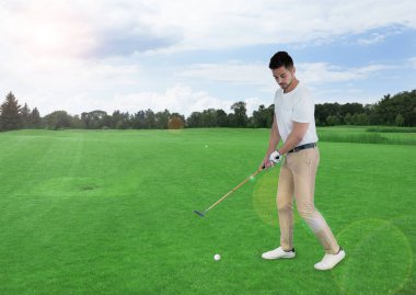 Genç adam yeşil çimlerle golf oynuyor. Tasarım için boşluk