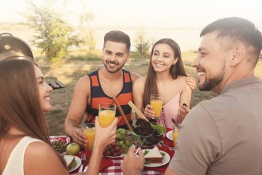 Mutlu gençler parkta piknik yapıyorlar.