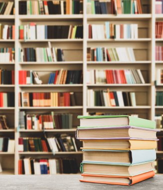 Kütüphanedeki masada renkli kitap yığını, metin için boşluk  