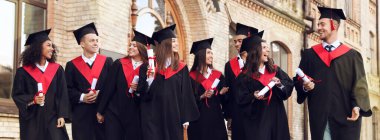 Kampüs yakınlarında diploması olan mutlu öğrenciler. Pankart tasarımı