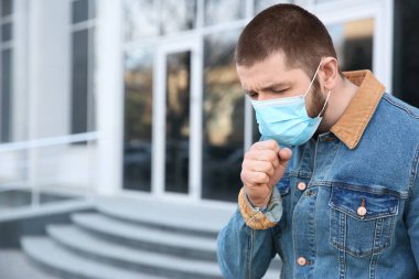 Açık havada tek kullanımlık maske takan bir adam. Tehlikeli bir virüs.