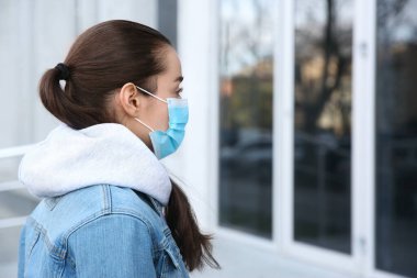 Açık havada tek kullanımlık maske takan bir kadın. Tehlikeli bir virüs.