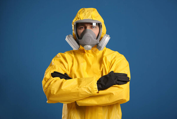 Man wearing chemical protective suit on blue background. Virus research
