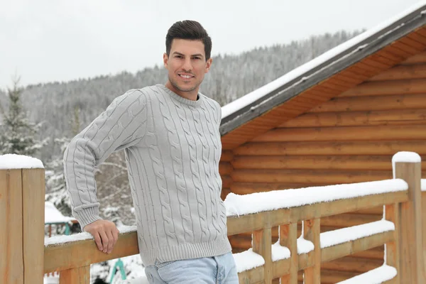 幸せな男で暖かいセーター近く木製の手すり屋外 — ストック写真
