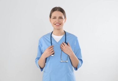 Steteskobu arka planda olan genç bir doktor.