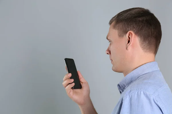 男子打开智能手机与灰色背景的面部扫描仪 文字空间 生物鉴别核查 — 图库照片