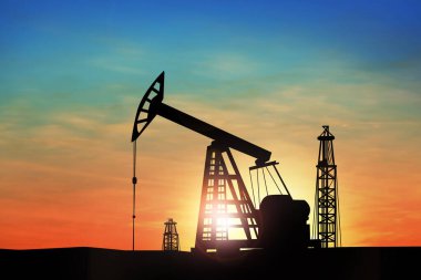 Gün batımında ham petrol pompasının silueti