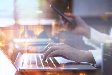 Dizüstü bilgisayar ve şehir manzarası kullanarak kadın programcının iki kez görüntülenmesi. 