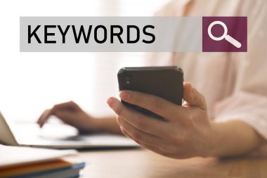 KEYWORDS mesajlı arama çubuğu ve masada çalışan akıllı telefonlu kadın, yakın plan