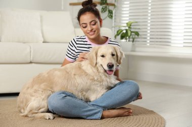 Genç kadın ve onun Golden Retriever 'ı evde. Sevimli hayvan.