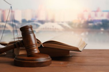 Yargıç tokmağı ve kitap ahşap masa üzerinde güzel şehir manzarasına karşı 