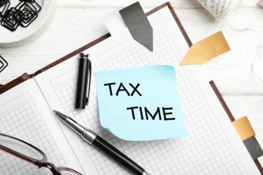 Sözcüklerle hatırlatma notu: Vergi Time ve masadaki kırtasiye, düz yatay