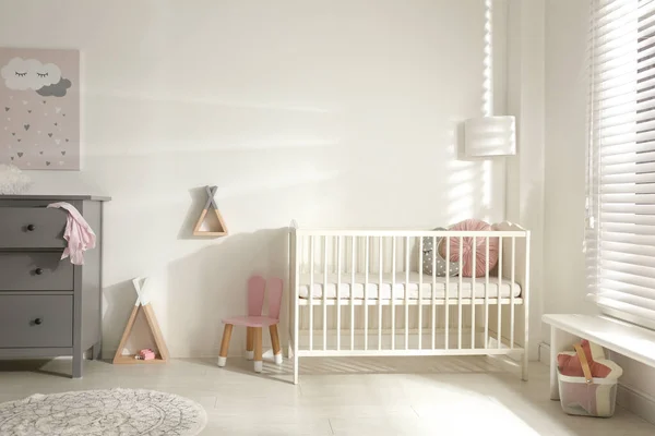 可爱的婴儿房内部有婴儿床和装饰元素 — 图库照片