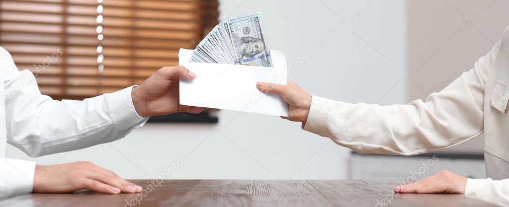 Woman giving bribe money to man at table indoors, closeup. Banner design