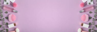 Mor arka planda yüz temizleme fırçaları ve kozmetik ürünleri olan düz kompozisyon, metin için boşluk. Pankart tasarımı