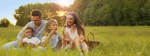 Gelukkig Gezin Picknicken Zeepbellen Blazen Het Park Bij Zonsondergang Ruimte — Stockfoto
