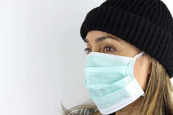 Woman wearing beanie and a virus mask for the prevention of the corona virus