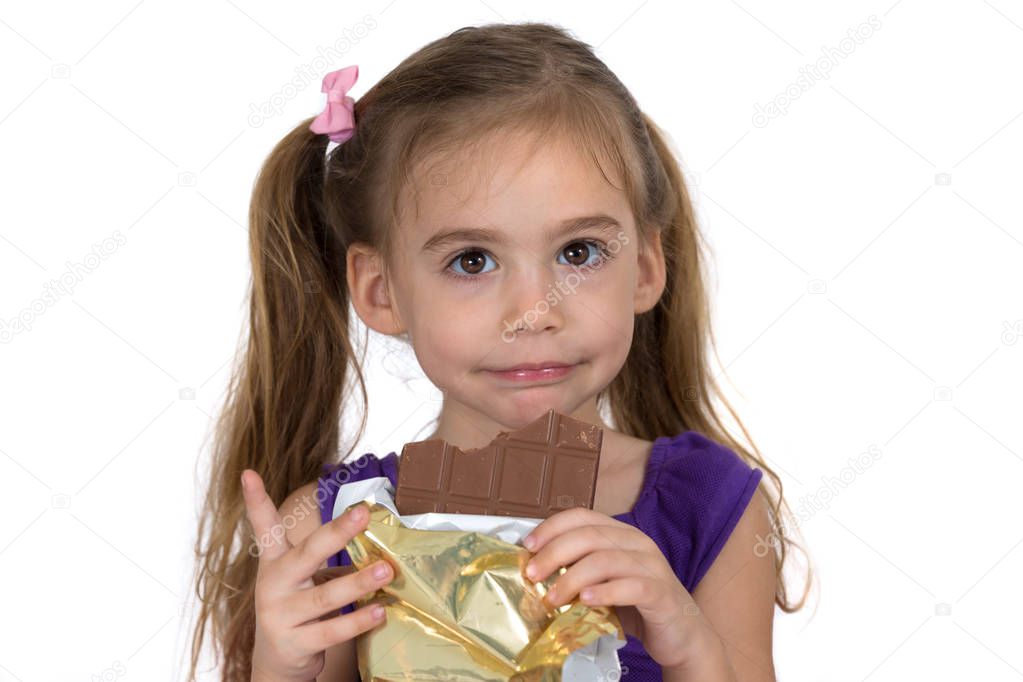 A four-year-old girl eats chocolate and makes a gesture