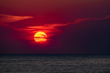 Güzel, renkli ve zıt bir gün batımı denizin üzerinde, okyanusun üzerinde. Sıcak güneş geniş araziyi aydınlatarak su yüzeyine ışıldayan ışınlar saçar. Parlak Sunny gün doğumu. Seyahat ve turizm