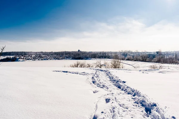 Spacious snow landscape. River and hills in Russia, white winter on the terrain, a lot of fluffy snow and ice under a beautiful blue sky. Rostov region, town of Shakhty, the river Grushevka