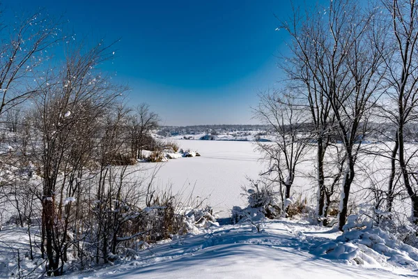 Spacious snow landscape. River and hills in Russia, white winter on the terrain, a lot of fluffy snow and ice under a beautiful blue sky. Rostov region, town of Shakhty, the river Grushevka