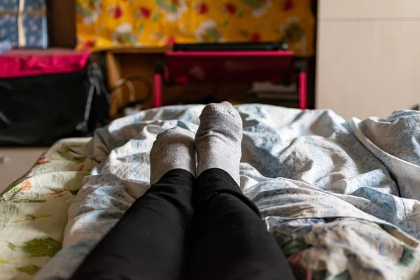 Cienkie Kobiece Nogi Stopy Czarnych Spodniach Szare Skarpetki Leżą Łóżku — Zdjęcie stockowe