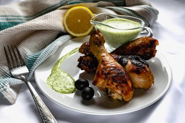 Kızarmış tavuk budu, kahverengi altın hamurlu ve taze soslu limon ve siyah zeytinlerle süslenmiş beyaz desenli peçeteyle, havluyla