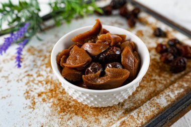 Tatlı ve yumuşak kurutulmuş elma ve tatlı için hazırlanmış gül kalçaları, alışılmadık beyaz ve paslı metal arka planda lavanta ve kuru meyvelerle süslenmiş.