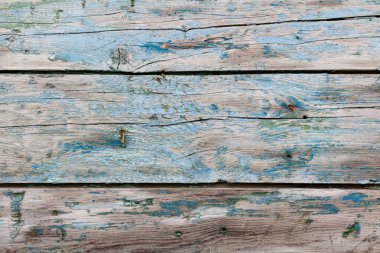 Boya soyan eski ahşap bir arka plan. Mavi ve yeşil kaplamalı klasik tahtalar. Kahverengi ve bej ahşap parçalarının üzerindeki akuamarin gölgeleri katı bir yüzeye çarpmış..