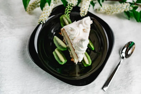 Una Rebanada Pastel Con Crema Merengue Plato Negro Brillante Con —  Fotos de Stock