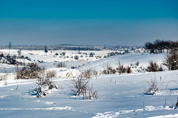 Spacious snow landscape. River and hills in Russia, white winter on the terrain, a lot of fluffy snow and ice under a beautiful blue sky. Rostov region, town of Shakhty, the river Grushevka