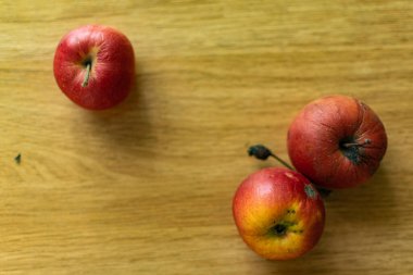 Parlak sulu meyveler, doğal ve doğal meyveler. Modern kahverengi ışıklı bir masada kırmızı elmalar ve mandalinalar.