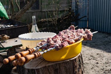 Şişlerde çiğ domuz eti, porsiyonlar halinde kesilmiş, yakın zamanda ızgarada dumanla kızartıldığı için ateşe verilmiş..