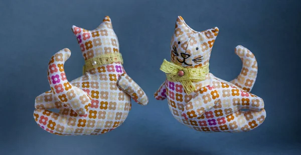 Flying reddish-brown cats. A handmade toys with a bow around his neck. From a cloth with a pattern, soft. Kind, pleasant, smiling cats.