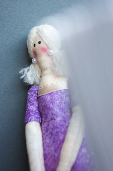紫色のドレスで悲しい人形が壁に立っています — ストック写真