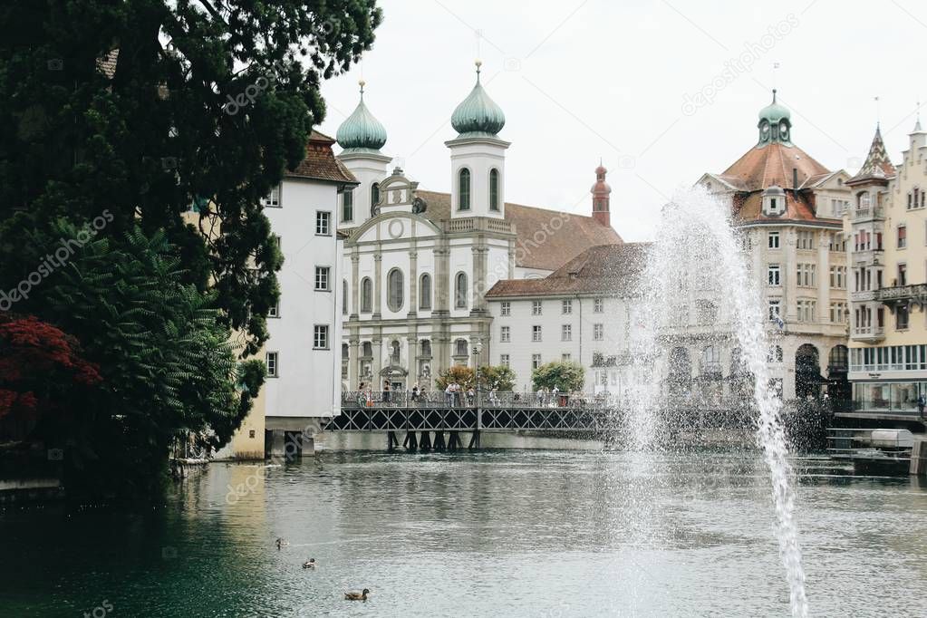 Idyllic view of old town building by lake with floating ducks 