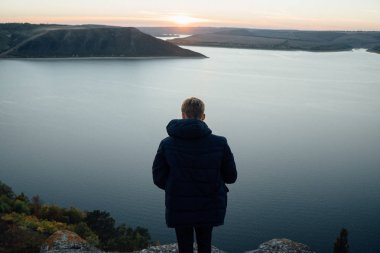 Nehir kıyısında ayakta ve manzara hayran insanın arkadan görünüş