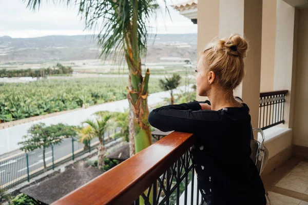 Sarışın kadın eğilerek balkon korkuluk ve manzaranın yan görünüm