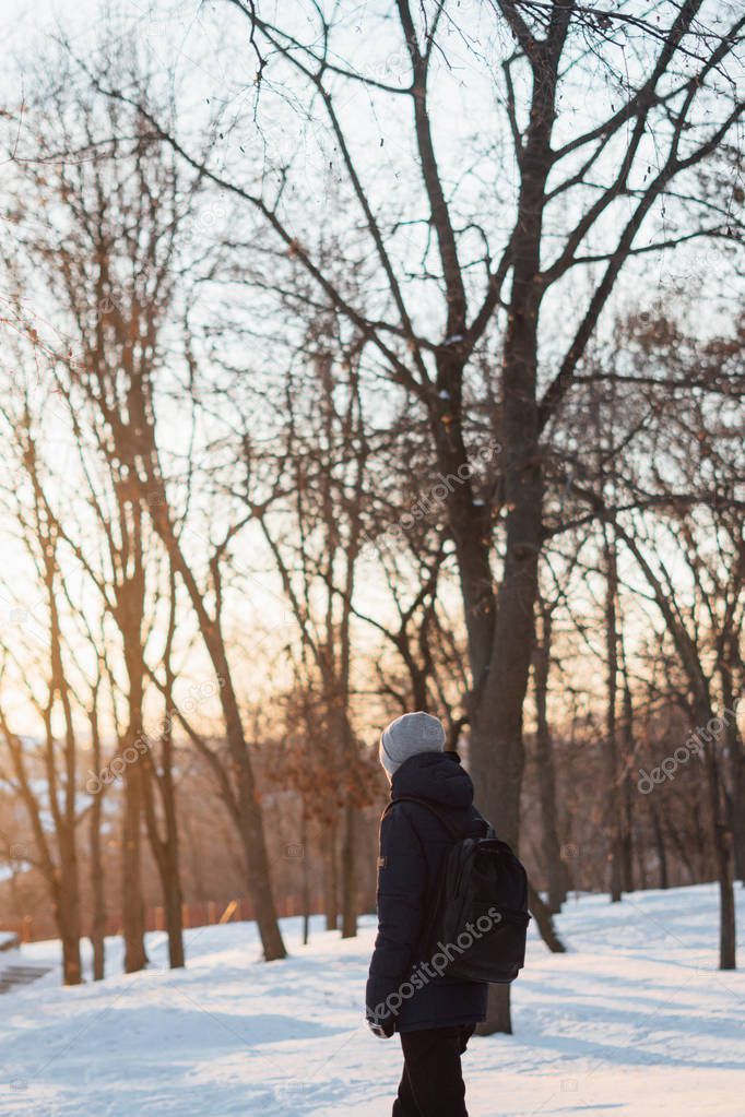 Rear view of young man walking at winter nature 