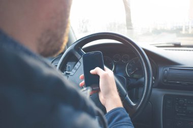 Yakışıklı adam araba sürüş sırasında Smartphone kullanarak