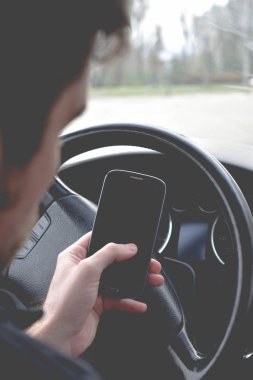 Yakışıklı adam araba sürüş sırasında Smartphone kullanarak