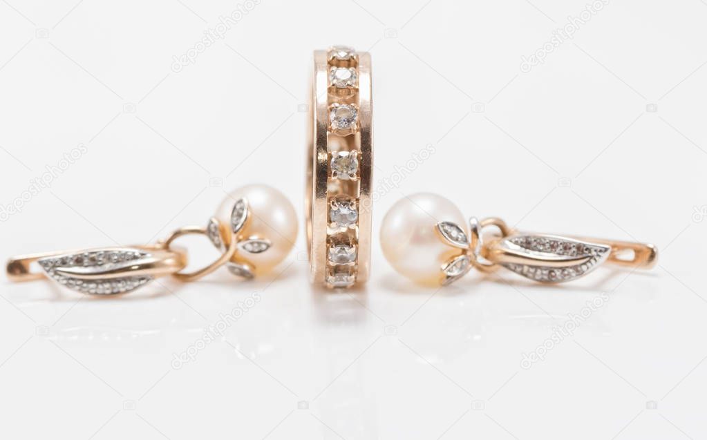 Elegant gold earrings with pearls and a chunky ring with small d