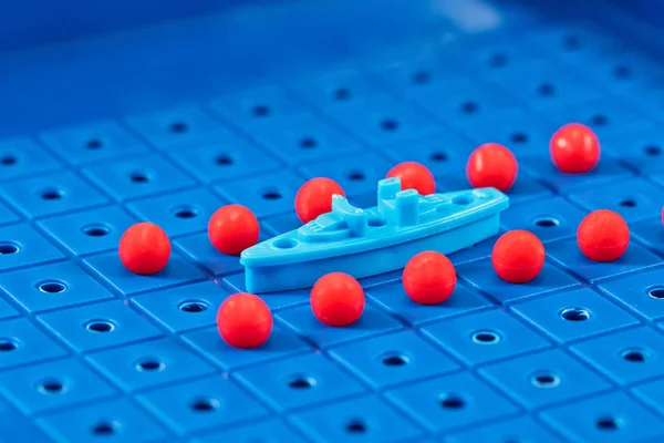 Toy war ship surrounded by a corridor of underwater mines