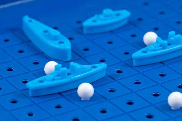 Toy war ships and a submarine lined up to play a Board game