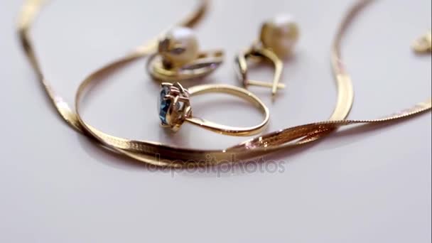 Anillo de oro con topacio y pendientes de perlas en un soporte giratorio — Vídeos de Stock