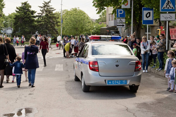 A police car slowly sneaking through the crowd of people celebra